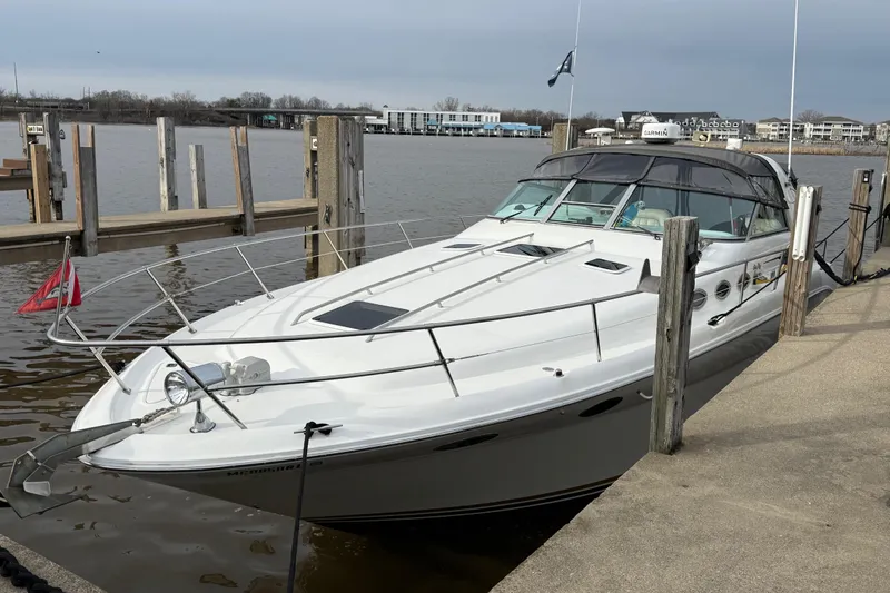The Image of 1995 Sea Ray Sundancer 370 docked at a marina, showcasing sleek design and spacious deck. - 0