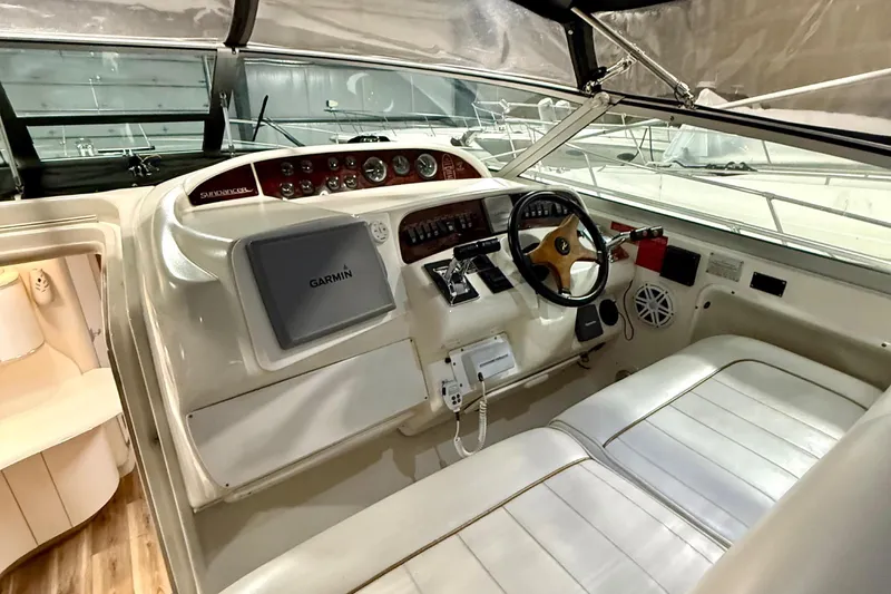 Slide: The Image of 1995 Sea Ray Sundancer 370 cockpit with steering wheel and navigation equipment. - 11