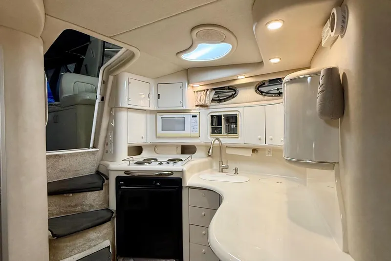 Slide: The Image of Interior of 1995 Sea Ray Sundancer 370 yacht, featuring a compact kitchen and modern design. - 15