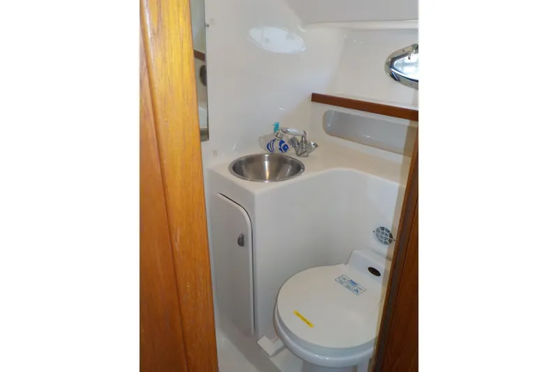Slide: The Image of Compact bathroom in 2001 Tiara Yachts 3100 Open, featuring sink and toilet. - 11