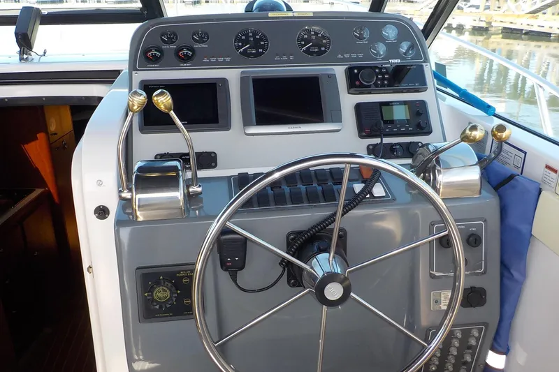 Slide: The Image of Helm of 2001 Tiara Yachts 3100 Open, featuring steering wheel and navigation controls. - 15