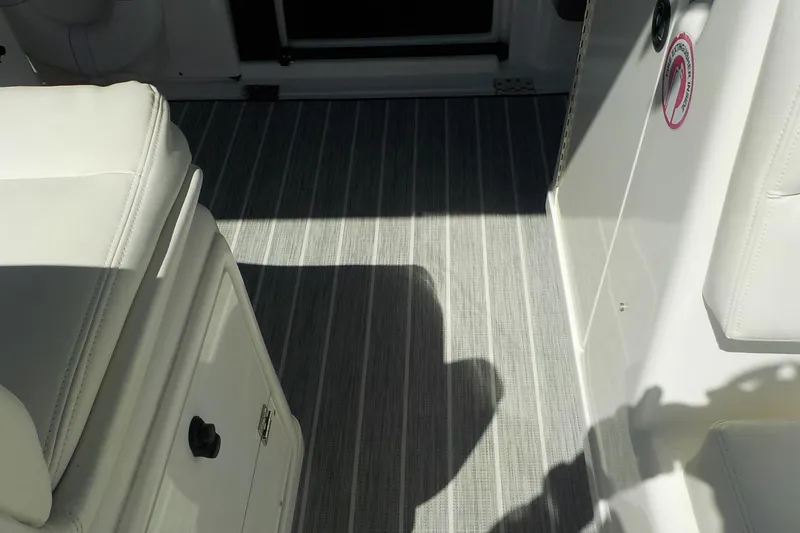 Slide: The Image of Interior of 2001 Tiara Yachts 3100 Open, featuring white seating and striped flooring. - 19