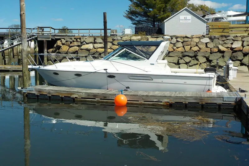 Slide: The Image of 2001 Tiara Yachts 3100 Open docked at a marina with rocky backdrop. - 2