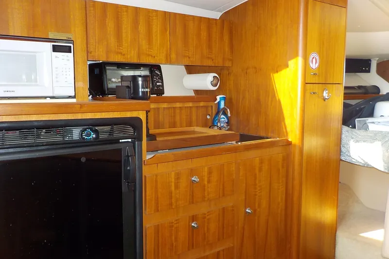 Slide: The Image of 2001 Tiara Yachts 3100 Open interior kitchen with wooden cabinetry and appliances. - 9