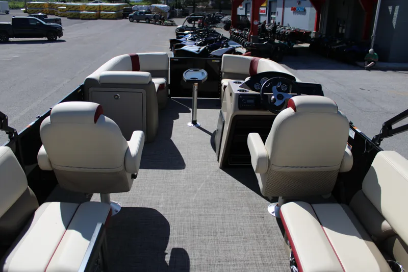 Slide: The Image of 2025 SunCatcher Select 20RC pontoon boat interior with beige seating and modern dashboard. - 12