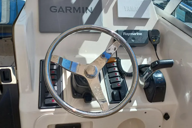 Slide: The Image of Steering console of 2013 Pursuit OS 255 Offshore boat with Garmin and Raymarine equipment. - 10