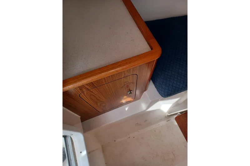 Slide: The Image of Interior of 2013 Pursuit OS 255 Offshore boat with wooden cabinetry and seating. - 12