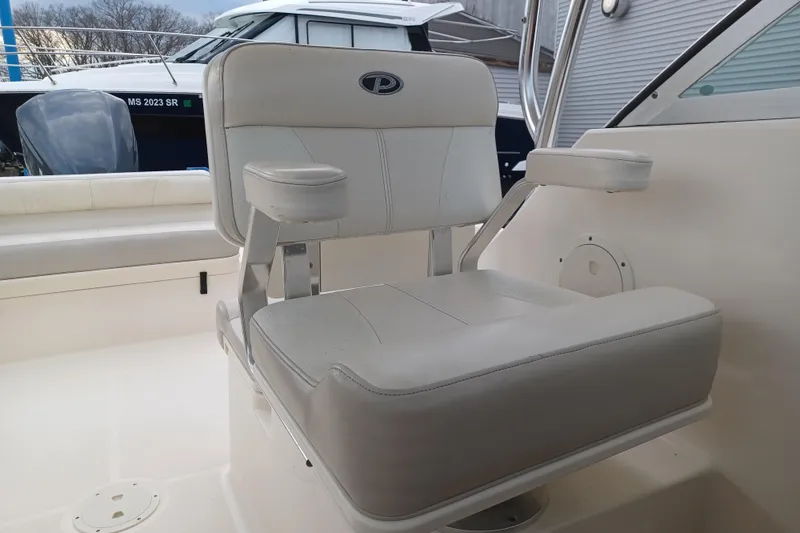 Slide: The Image of 2013 Pursuit OS 255 Offshore boat seat with armrests, white upholstery. - 18