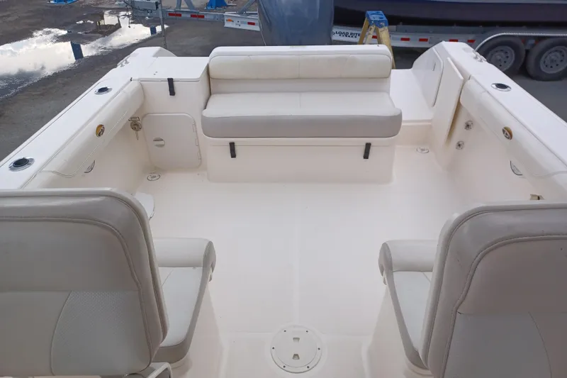 Slide: The Image of 2013 Pursuit OS 255 Offshore boat interior with white seating and spacious deck. - 19