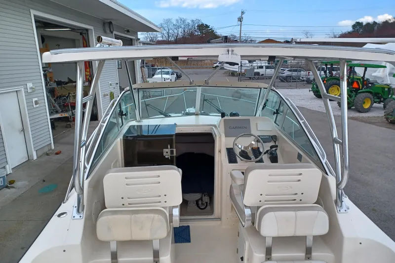 Slide: The Image of 2013 Pursuit OS 255 Offshore boat interior with dual seats and Garmin navigation system. - 21