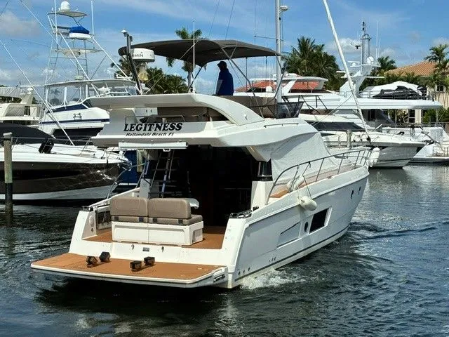 Slide: The Image of A 2017 Bavaria 420 VITRESS FLY yacht in a marina, featuring a flybridge and seating area. - 4