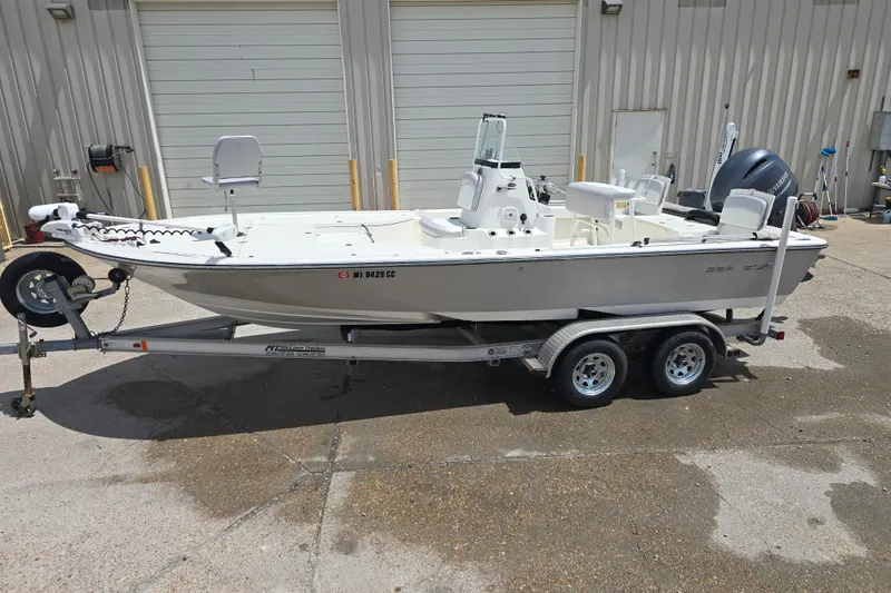 The Image of 2015 Sea Born FX22 Bay boat on trailer, parked outside a garage. - 0