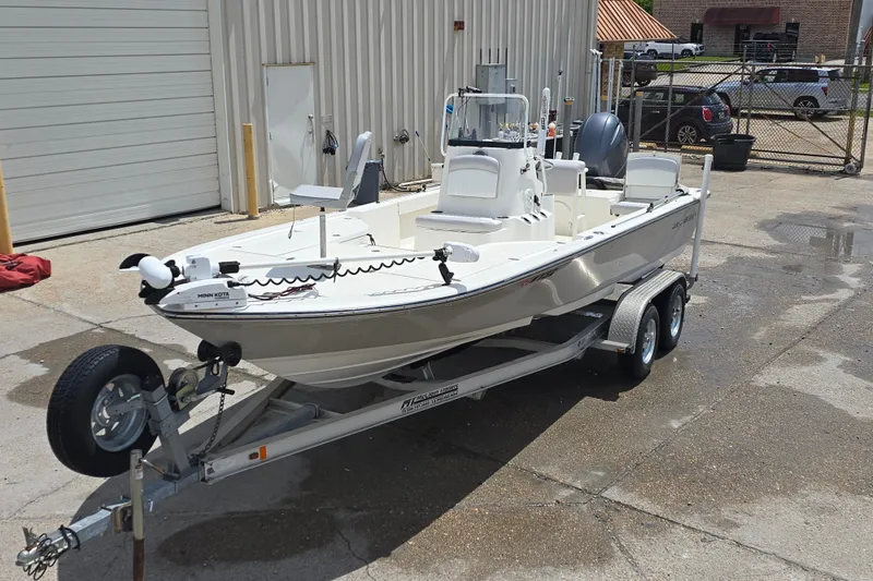Slide: The Image of 2015 Sea Born FX22 Bay boat on trailer, parked outside a garage. - 2