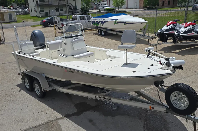 Slide: The Image of 2015 Sea Born FX22 Bay boat on trailer, parked outdoors with other watercraft nearby. - 4