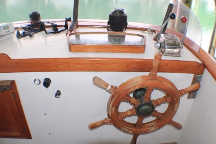 Slide: The Image of 1977 CHB Double Cabin boat helm with wooden wheel and navigation controls. - 10
