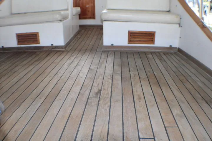 Slide: The Image of 1977 CHB Double Cabin boat interior with wooden flooring and cushioned seating. - 11