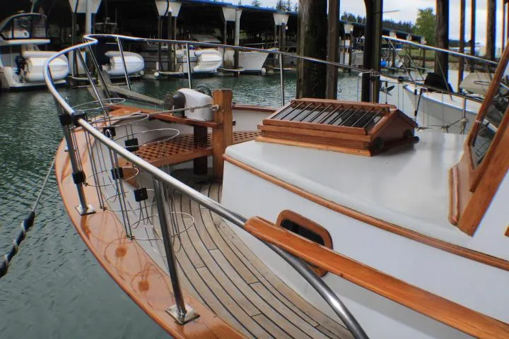 Slide: The Image of 1977 CHB Double Cabin boat with wooden deck and railing in a marina. - 15