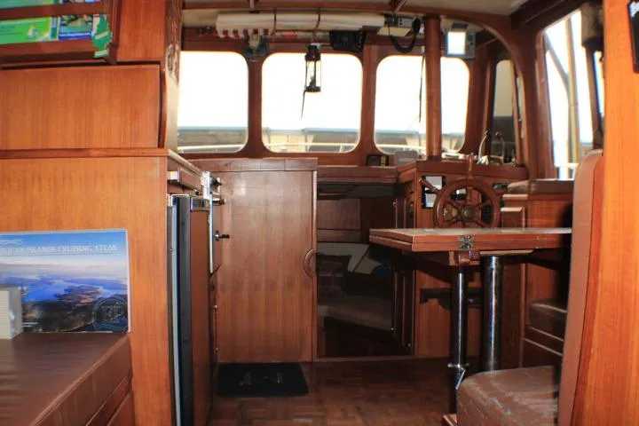 Slide: The Image of Interior of a 1977 CHB Double Cabin boat with wooden furnishings and helm. - 20