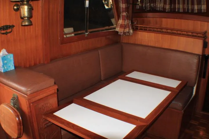 Slide: The Image of 1977 CHB Double Cabin interior with wooden dining area and brown seating. - 26