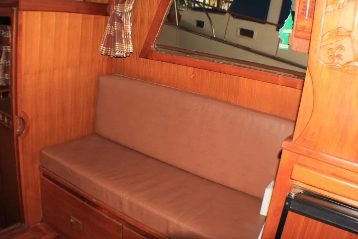 Slide: The Image of 1977 CHB Double Cabin interior with wooden paneling and brown cushioned seating. - 27