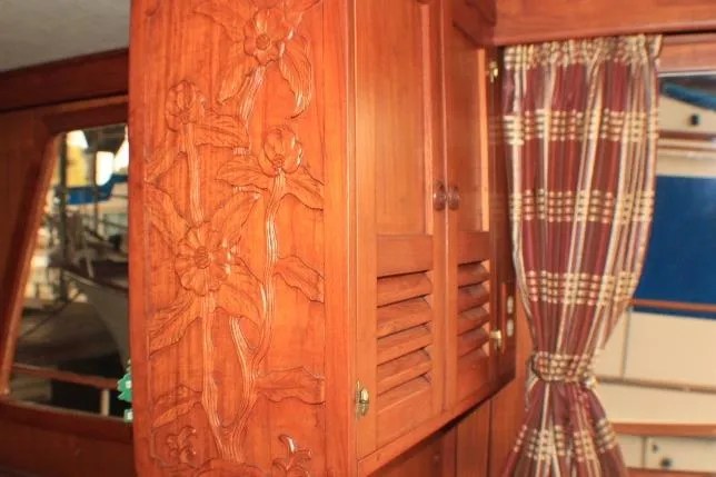 Slide: The Image of Wooden interior of 1977 CHB Double Cabin with floral carvings and plaid curtains. - 32