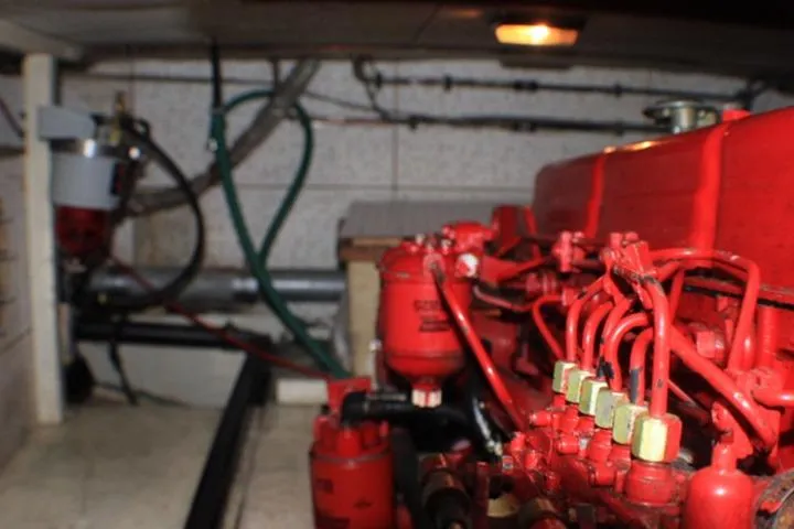 Slide: The Image of Engine room of a 1977 CHB Double Cabin boat, featuring red mechanical components. - 36