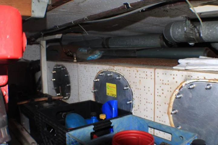 Slide: The Image of Engine room of a 1977 CHB Double Cabin boat with storage containers and maintenance equipment. - 40