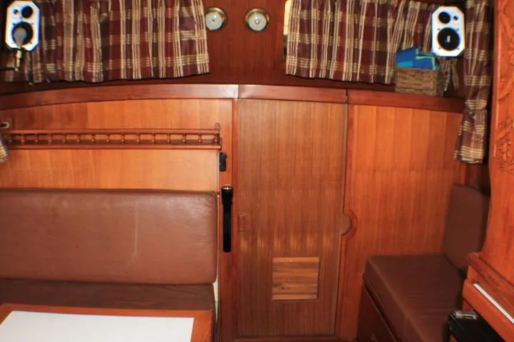 Slide: The Image of 1977 CHB Double Cabin interior with wood paneling, plaid curtains, and seating area. - 42