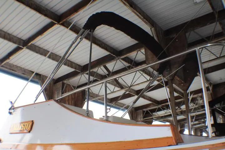 Slide: The Image of 1977 CHB Double Cabin boat under a covered dock, showcasing its structure and design. - 5