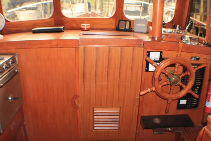 Slide: The Image of 1977 CHB Double Cabin boat interior with wooden helm and navigation equipment. - 51