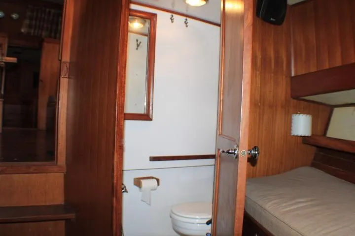Slide: The Image of 1977 CHB Double Cabin interior with wooden paneling, compact bathroom, and cozy sleeping area. - 55