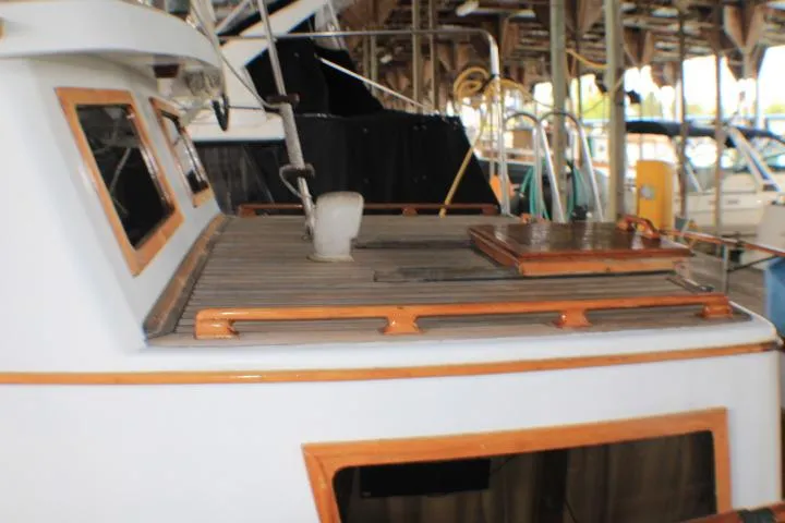 Slide: The Image of 1977 CHB Double Cabin boat with wooden deck, docked in a marina. - 6