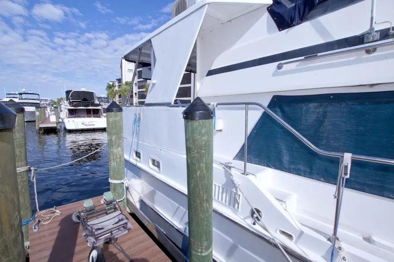 Slide: The Image of 1984 Present Yachts 42 Sundeck docked at marina under blue sky. - 11