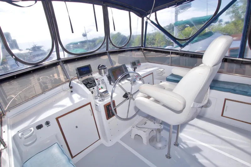 Slide: The Image of 1984 Present Yachts 42 Sundeck helm with steering wheel, navigation equipment, and captain's chair. - 18