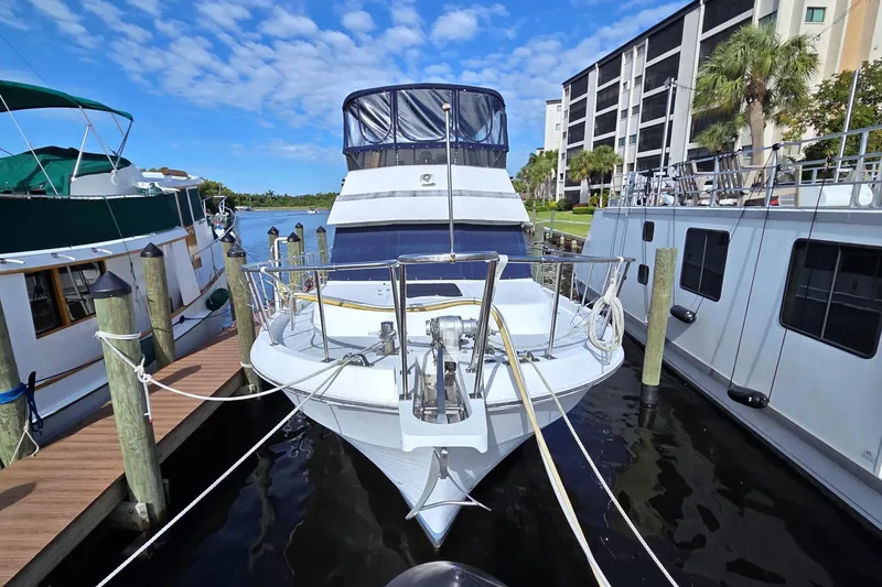 Slide: The Image of 1984 Present Yachts 42 Sundeck docked, showcasing sleek design and spacious deck. - 2