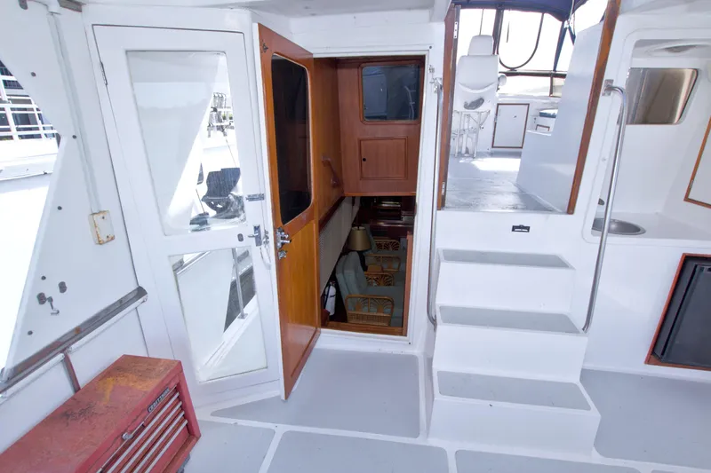 Slide: The Image of 1984 Present Yachts 42 Sundeck interior with stairs, wooden door, and seating area. - 27