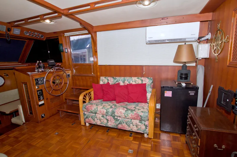 Slide: The Image of Interior of 1984 Present Yachts 42 Sundeck with floral sofa and wooden helm. - 31