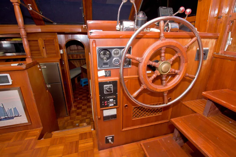 Slide: The Image of Interior of 1984 Present Yachts 42 Sundeck, featuring wooden helm and nautical controls. - 33
