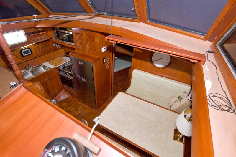 Slide: The Image of Interior of 1984 Present Yachts 42 Sundeck, featuring kitchen and dining area with wood finish. - 35