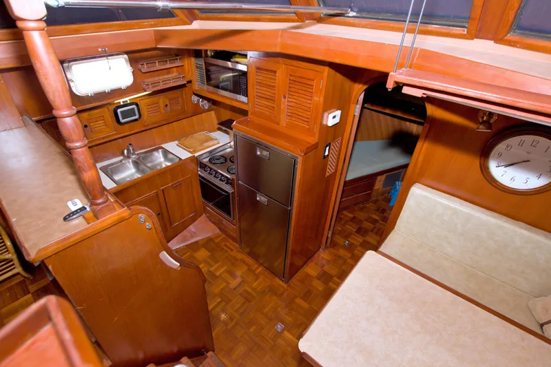 Slide: The Image of Interior of 1984 Present Yachts 42 Sundeck, featuring kitchen and dining area. - 36