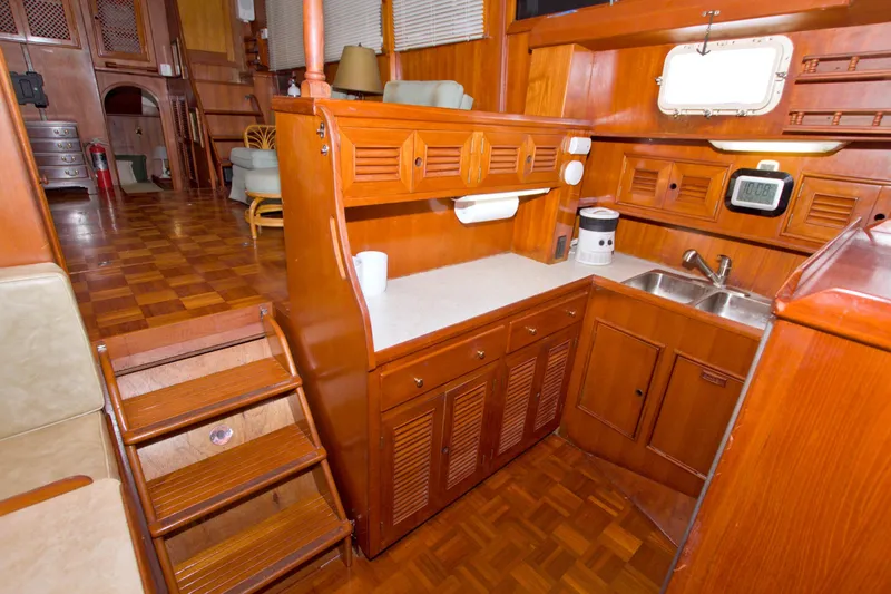 Slide: The Image of 1984 Present Yachts 42 Sundeck interior with wooden cabinetry and compact kitchen area. - 37
