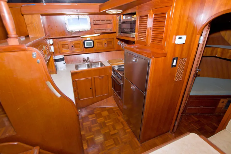 Slide: The Image of 1984 Present Yachts 42 Sundeck interior with wooden cabinetry and compact kitchen area. - 38