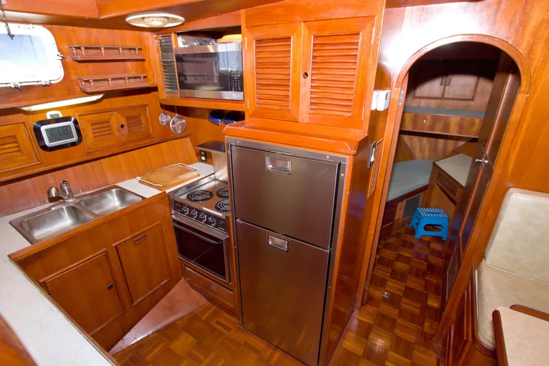 Slide: The Image of 1984 Present Yachts 42 Sundeck interior with wooden cabinetry and modern kitchen appliances. - 39