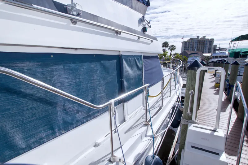 Slide: The Image of 1984 Present Yachts 42 Sundeck docked, featuring blue canvas and stainless steel railings. - 4