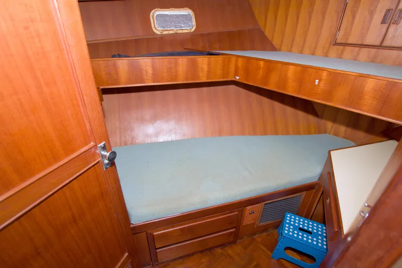 Slide: The Image of 1984 Present Yachts 42 Sundeck cabin interior with wooden bunk beds and storage. - 43