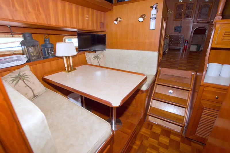 Slide: The Image of 1984 Present Yachts 42 Sundeck interior with dining area, wooden finish, and cozy seating. - 48