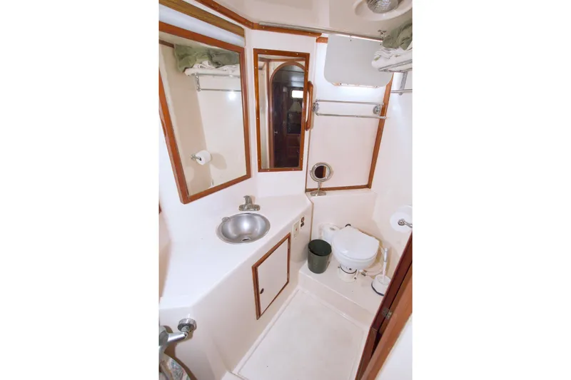 Slide: The Image of 1984 Present Yachts 42 Sundeck bathroom with sink, toilet, and mirror. - 59