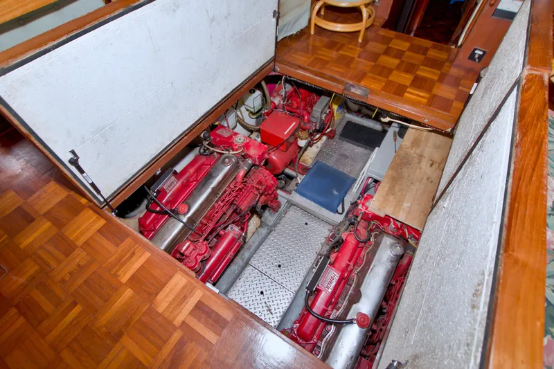 Slide: The Image of Engine room of a 1984 Present Yachts 42 Sundeck, showcasing dual red engines. - 67