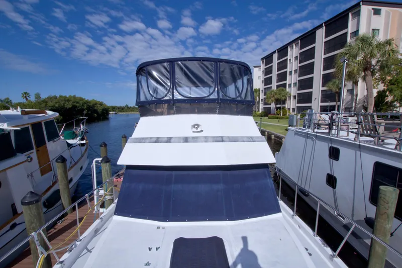 Slide: The Image of 1984 Present Yachts 42 Sundeck docked near waterfront buildings under blue sky. - 7