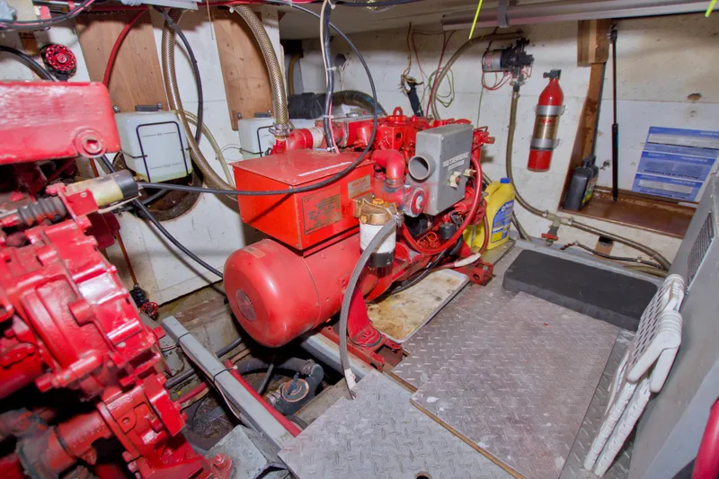 Slide: The Image of Engine room of a 1984 Present Yachts 42 Sundeck, featuring red machinery and equipment. - 70